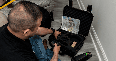 An inspector kneeling beside an open lead testing case